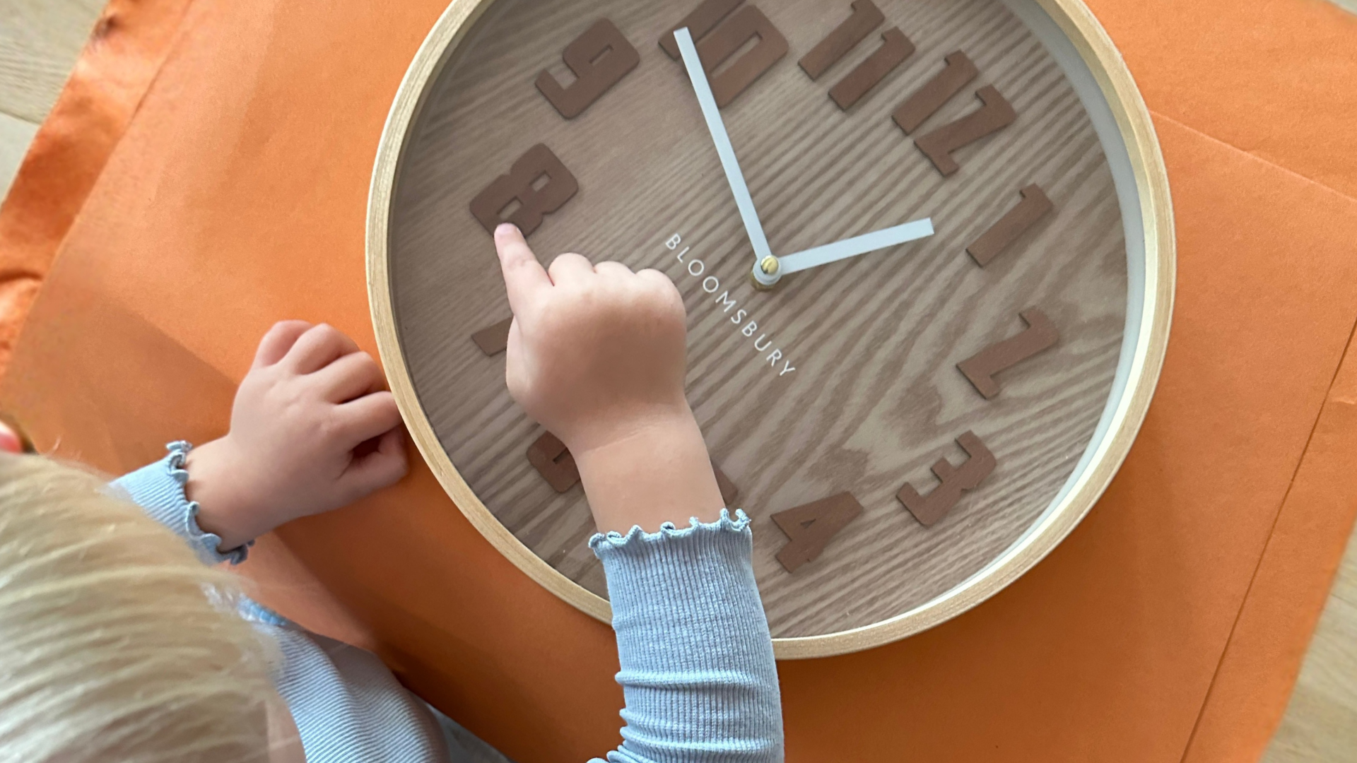 Child pointing at numbers on clock