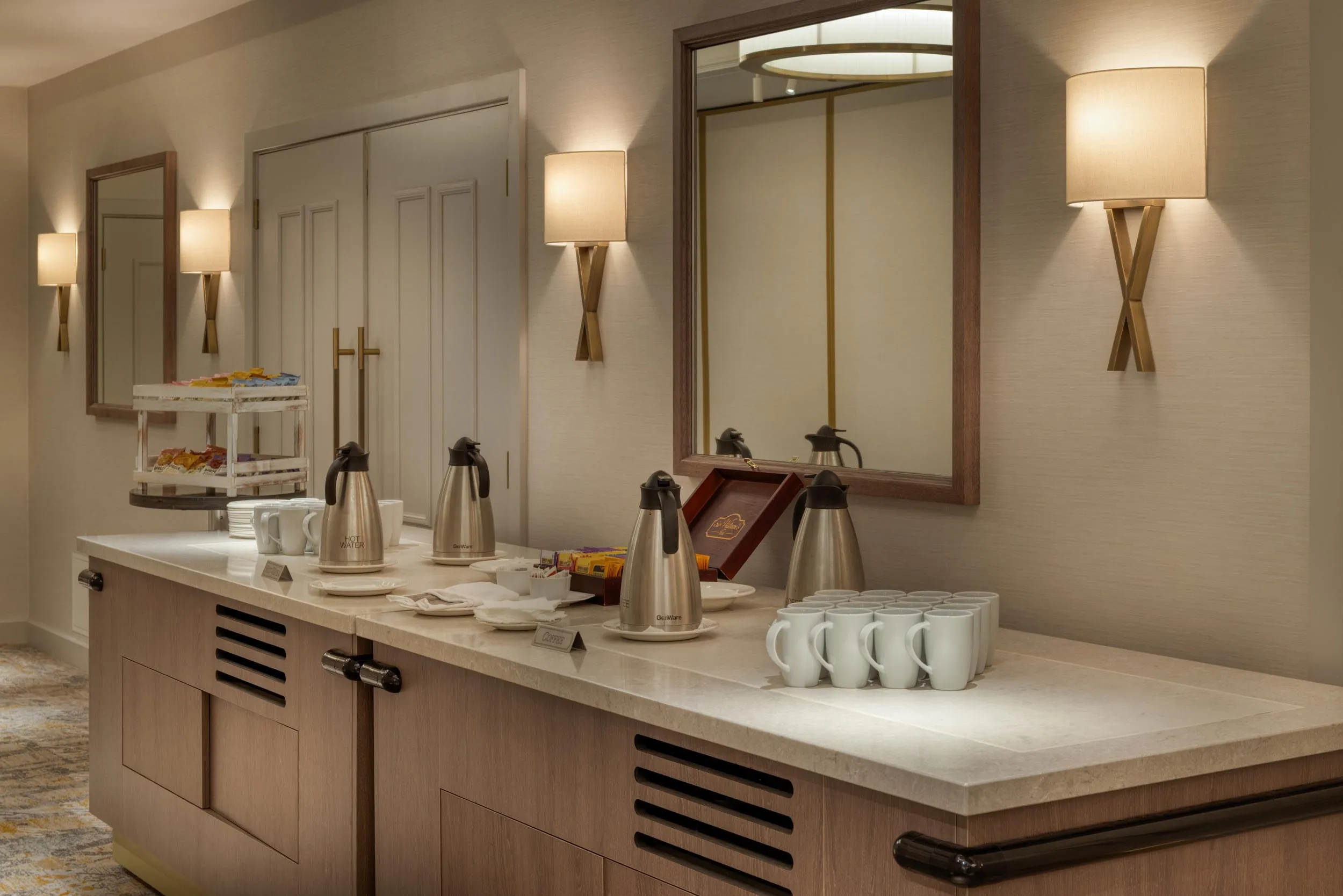 A kitchen counter with a coffee pot and cups.