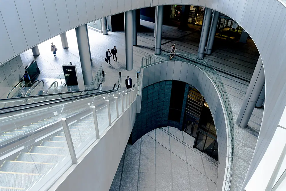Stockimage, taken from above of a corporate building with people walking up and down stairs in business suits.