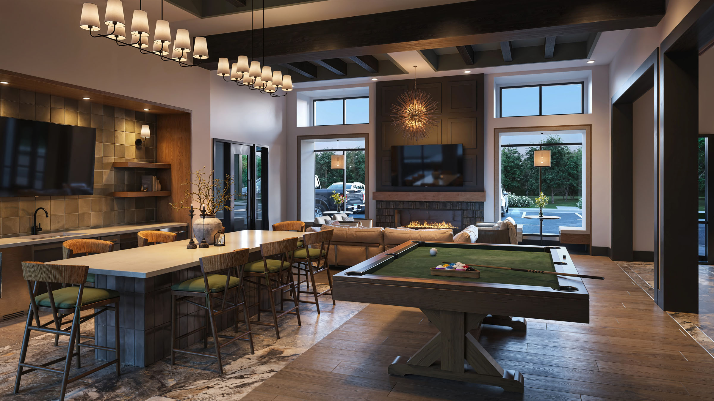Amenity lounge with billiards table, bar seating, and warm interior lighting.