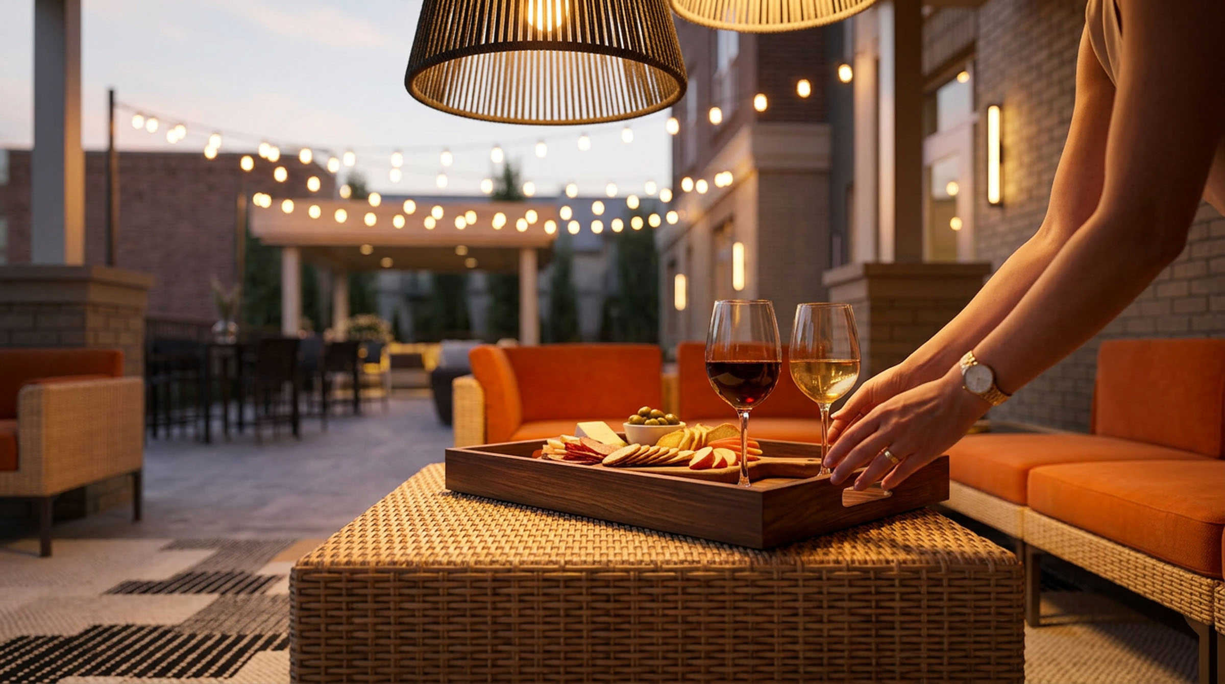 Rooftop lounge tray with drinks and snacks under evening string lights.
