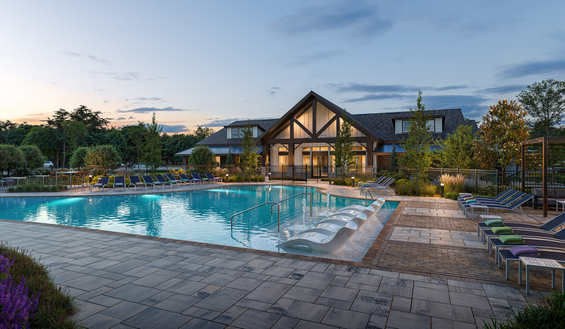 Spectrum Indian Trail pool deck rendering at dusk with surrounding community buildings - Indian Trail, North Carolina