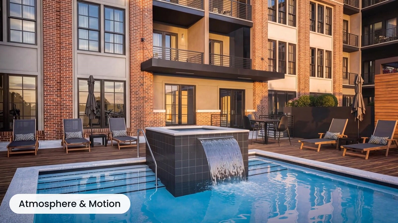 Apartment courtyard pool with illuminated water feature at dusk