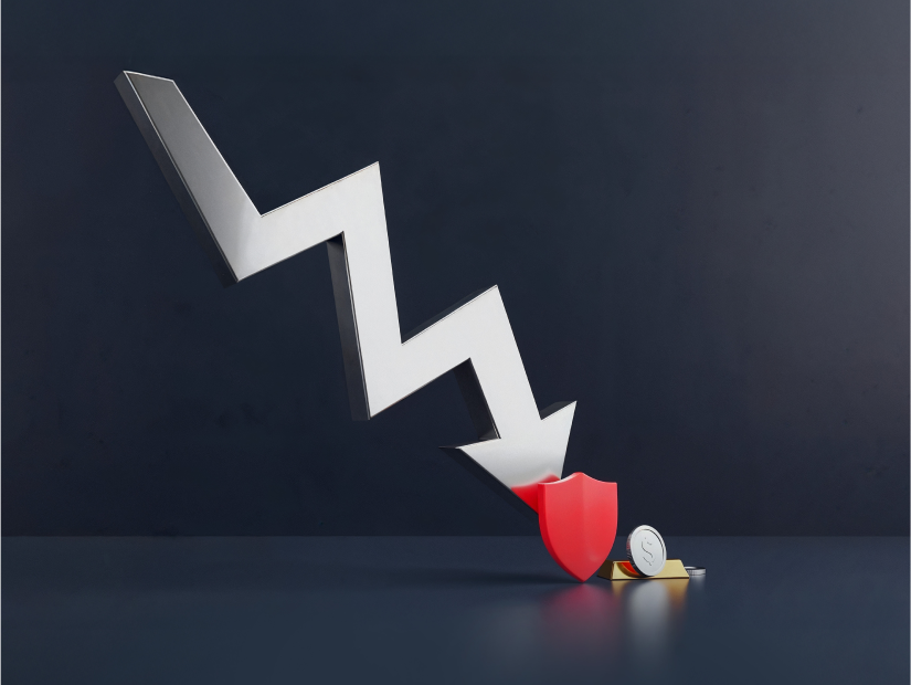 Falling zigzag arrow hitting a shield with coins, symbolising a stock market crash and ways to take advantage of it. 