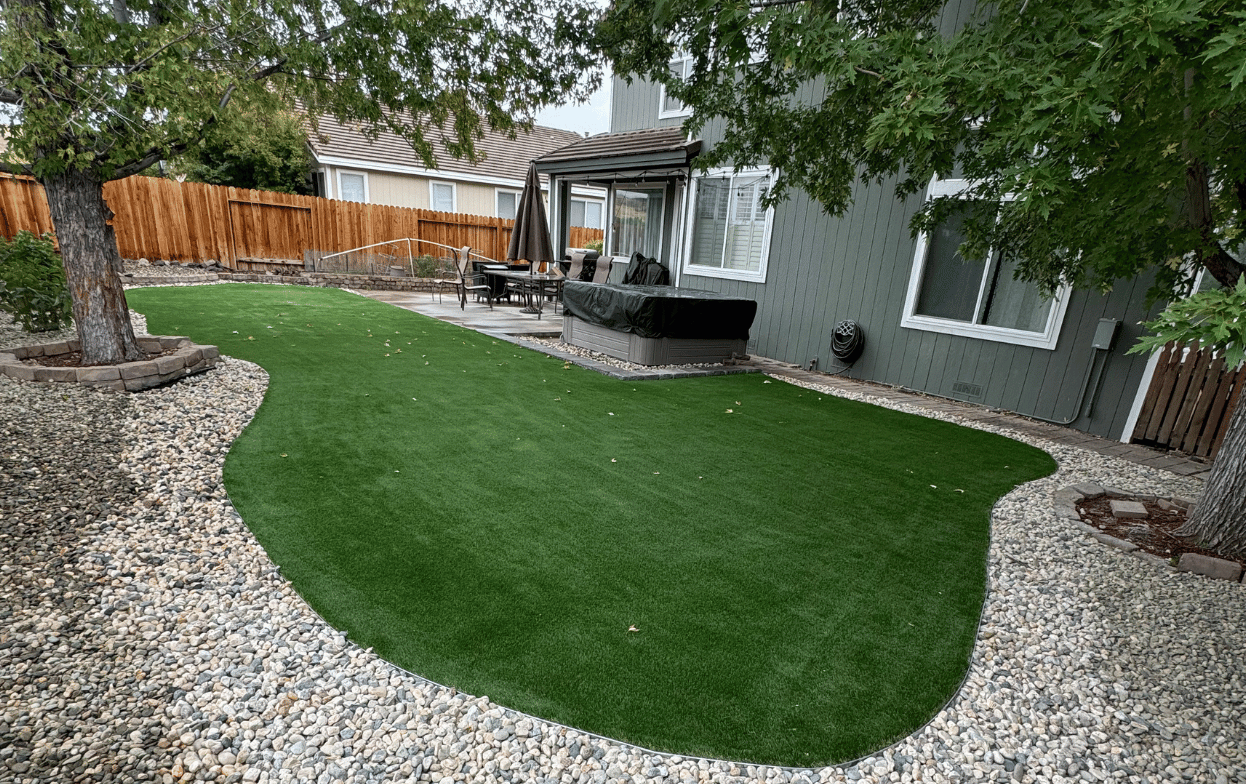 Backyard landscaping in Bountiful Utah featuring artificial turf and stone edging by Activescapes Landscaping