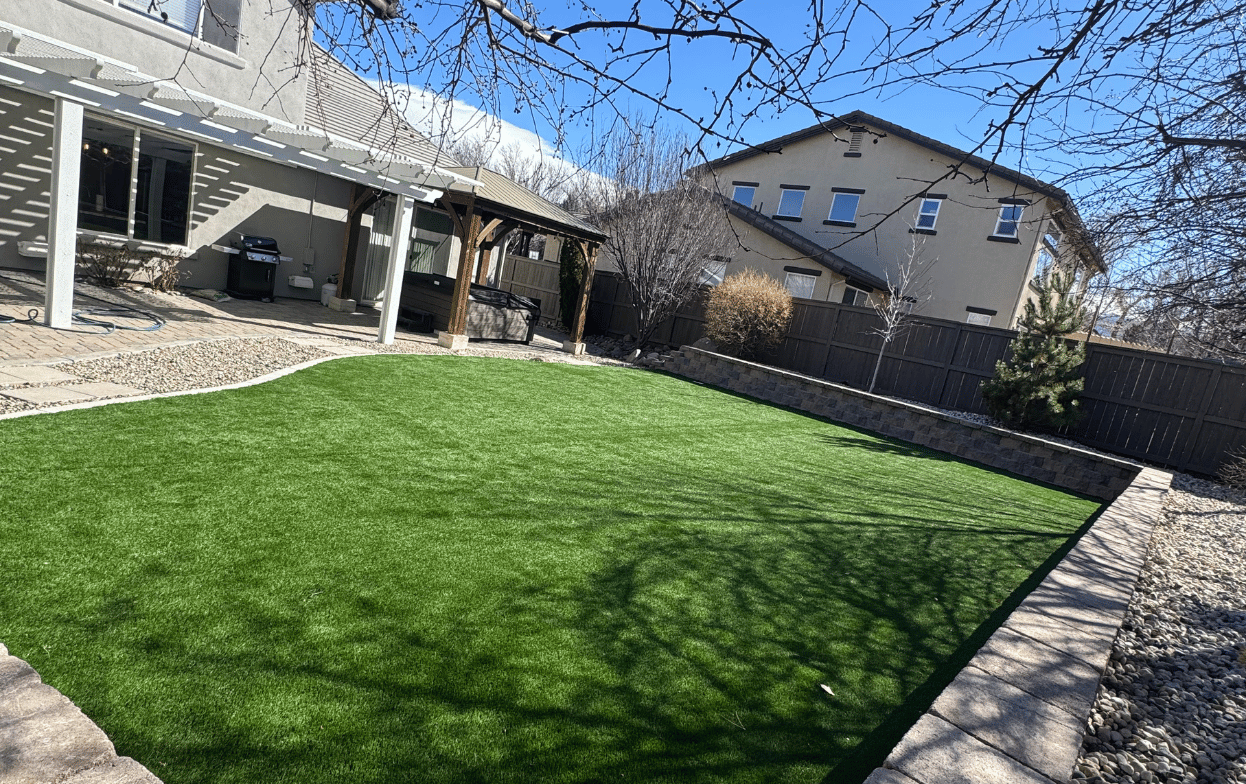 Backyard landscaping in North Salt Lake Utah with artificial turf and stone borders by Activescapes Landscaping