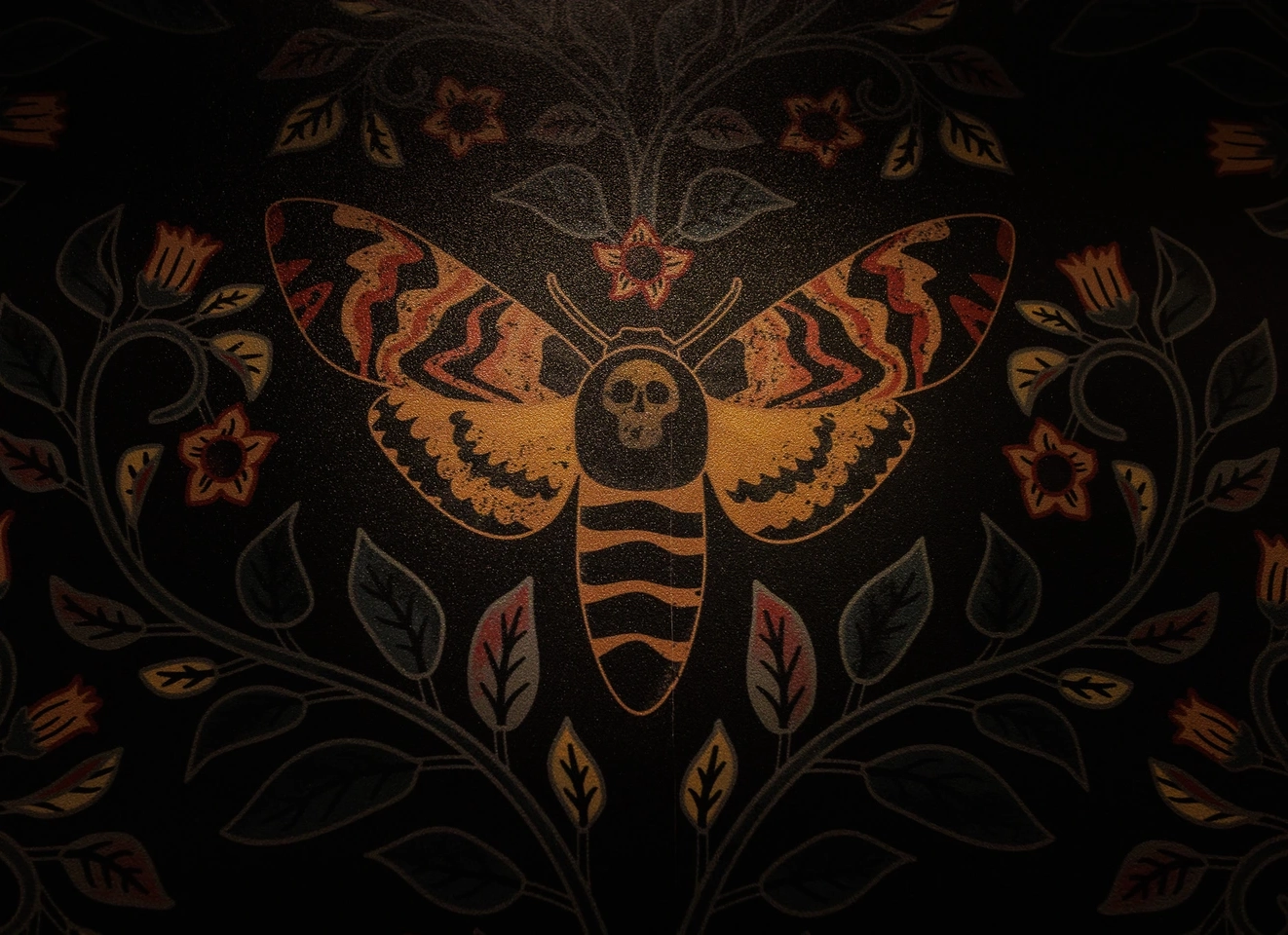 Dark wallpaper of a moth with skull, flowers, and leaves
