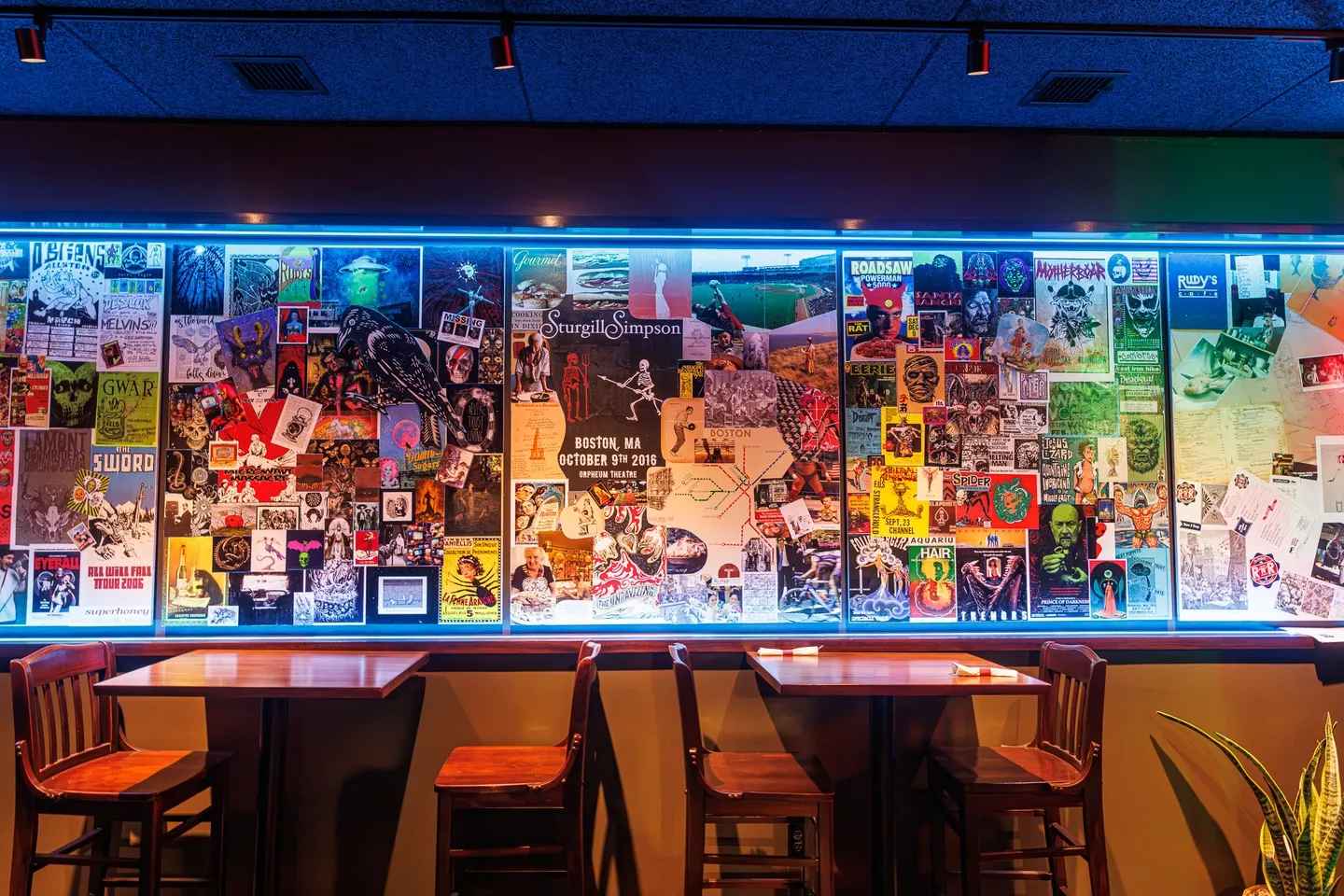 Wall above tables decorated with collaged posters and magazines