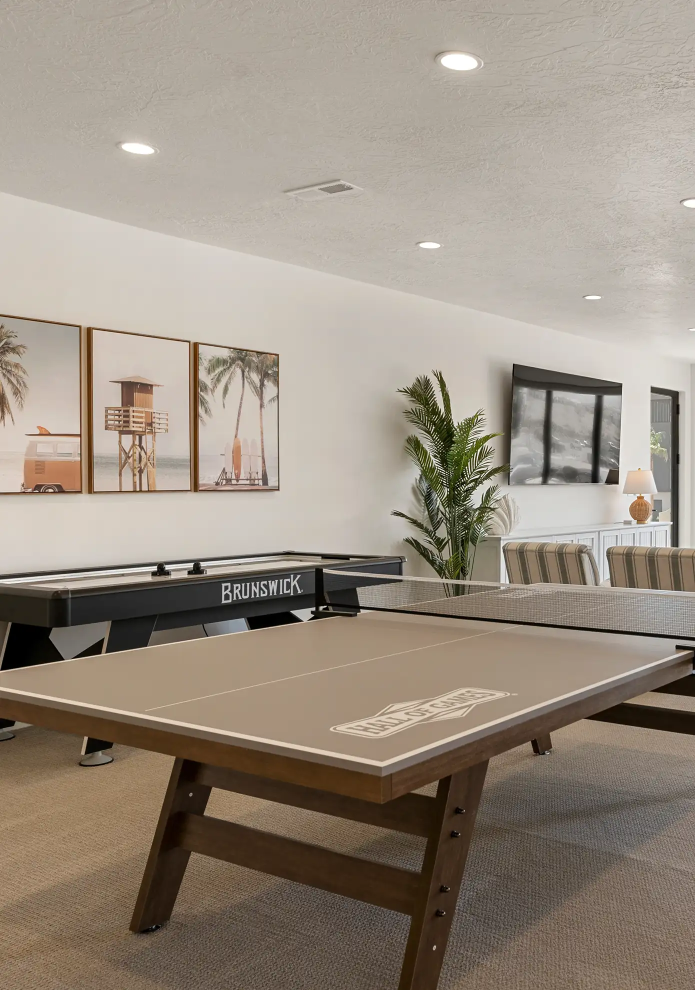 Game room with a ping-pong table, air hockey table, and lounge seating