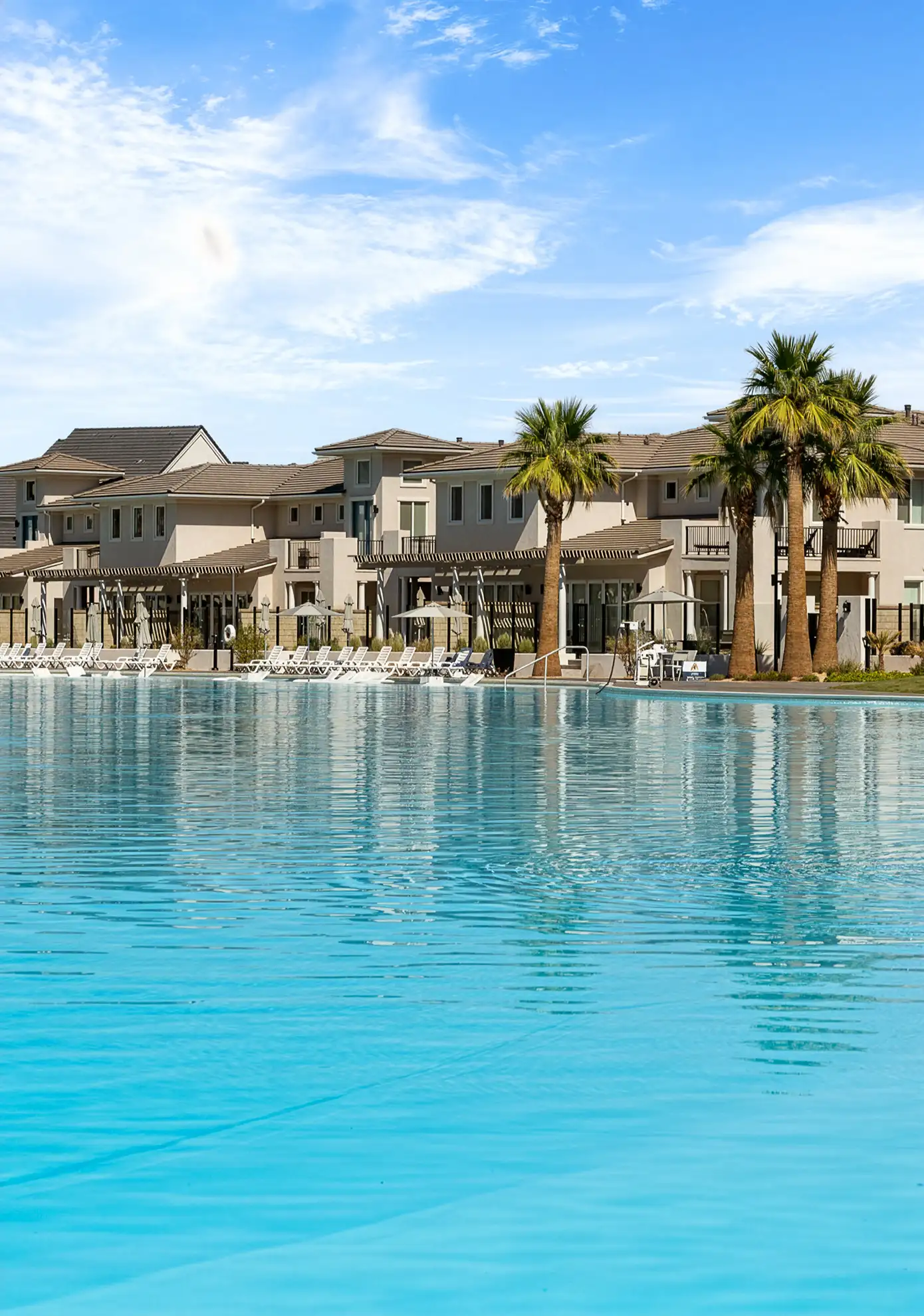 Turquoise lagoon lined with palm trees and resort-style homes