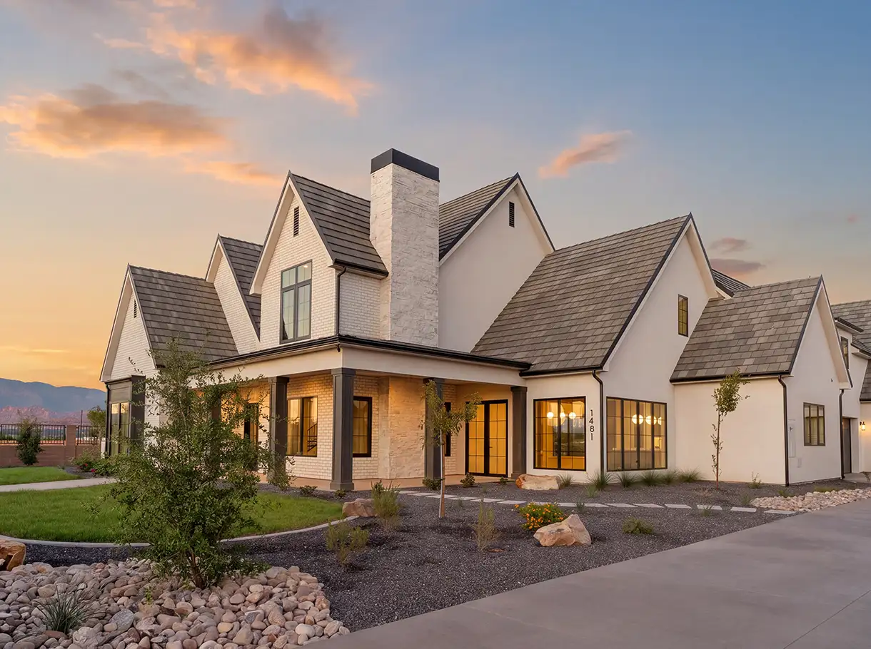 White farmhouse-style home with a covered front porch at sunset