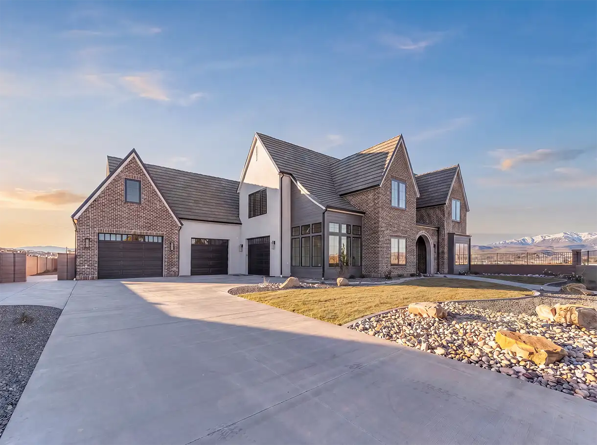 Brick and white stucco home with three garage doors and a wide driveway