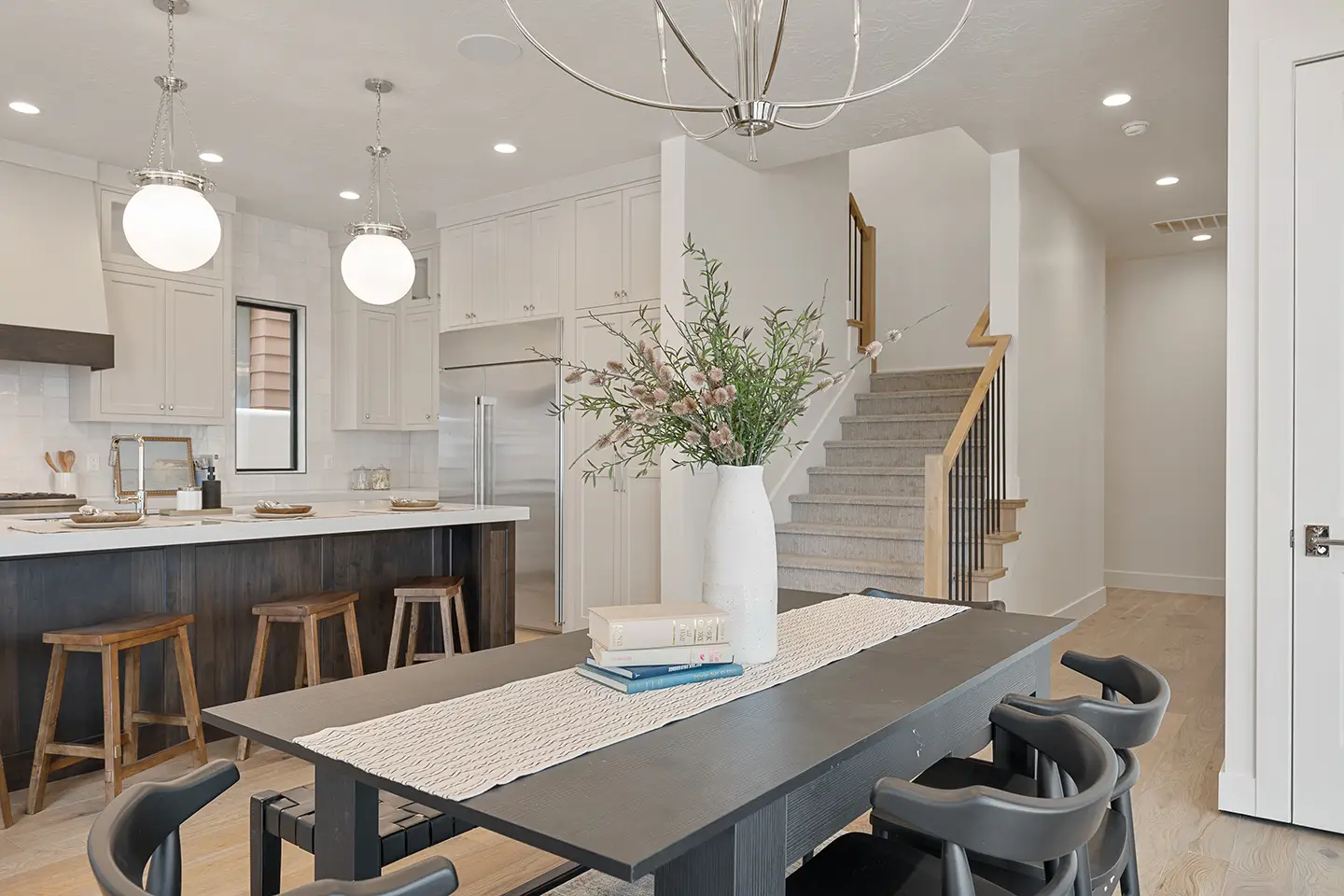 Desert Solace dining area with dark wood table and modern kitchen featuring island and pendant lights