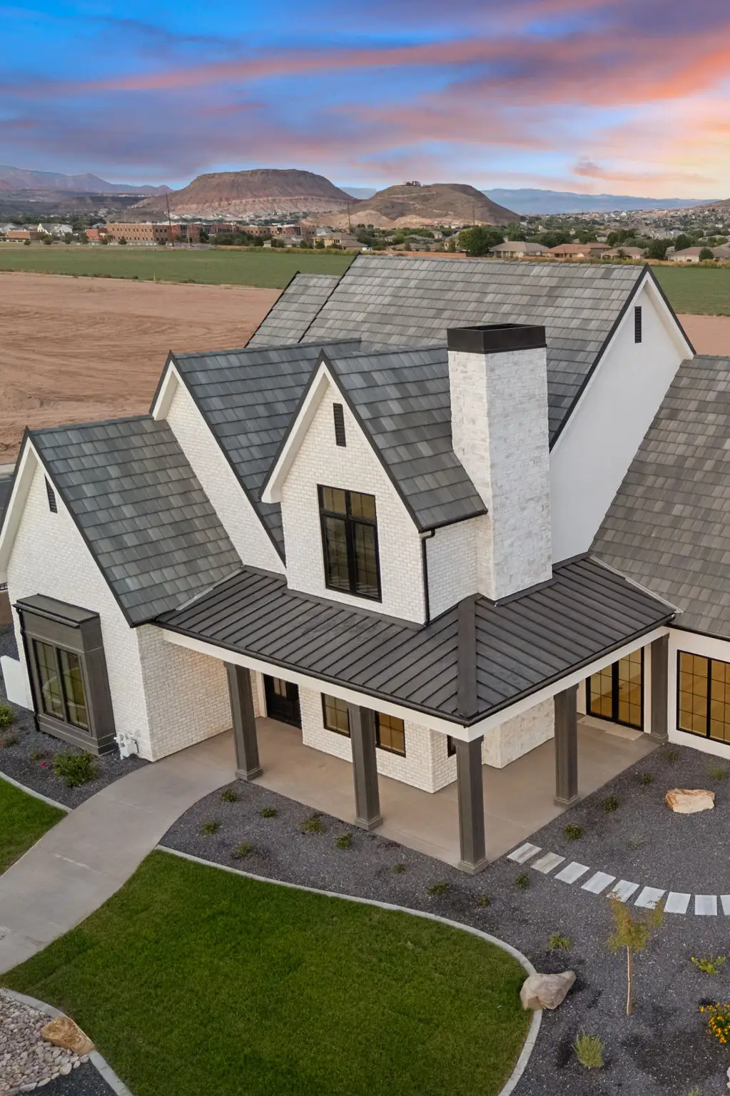 Aerial rear view of Villa Bellrose showing driveway, garage, and carport at sunset