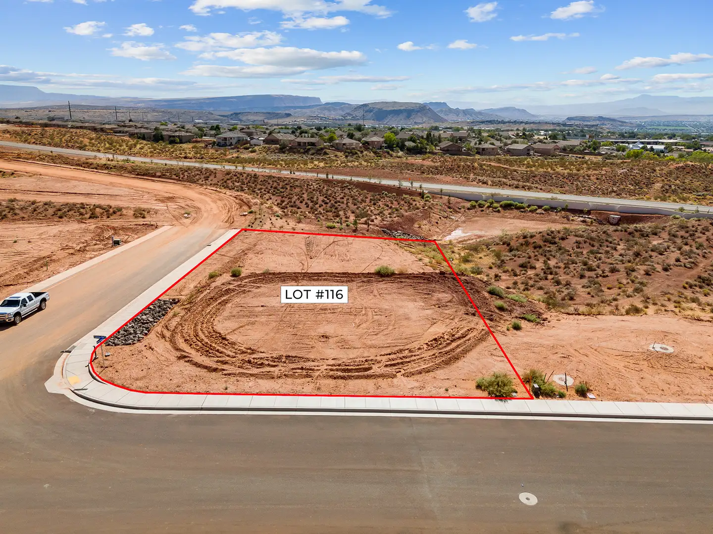 Aerial view of a highlighted cul-de-sac home lot outlined in red with mesa and town views in the background