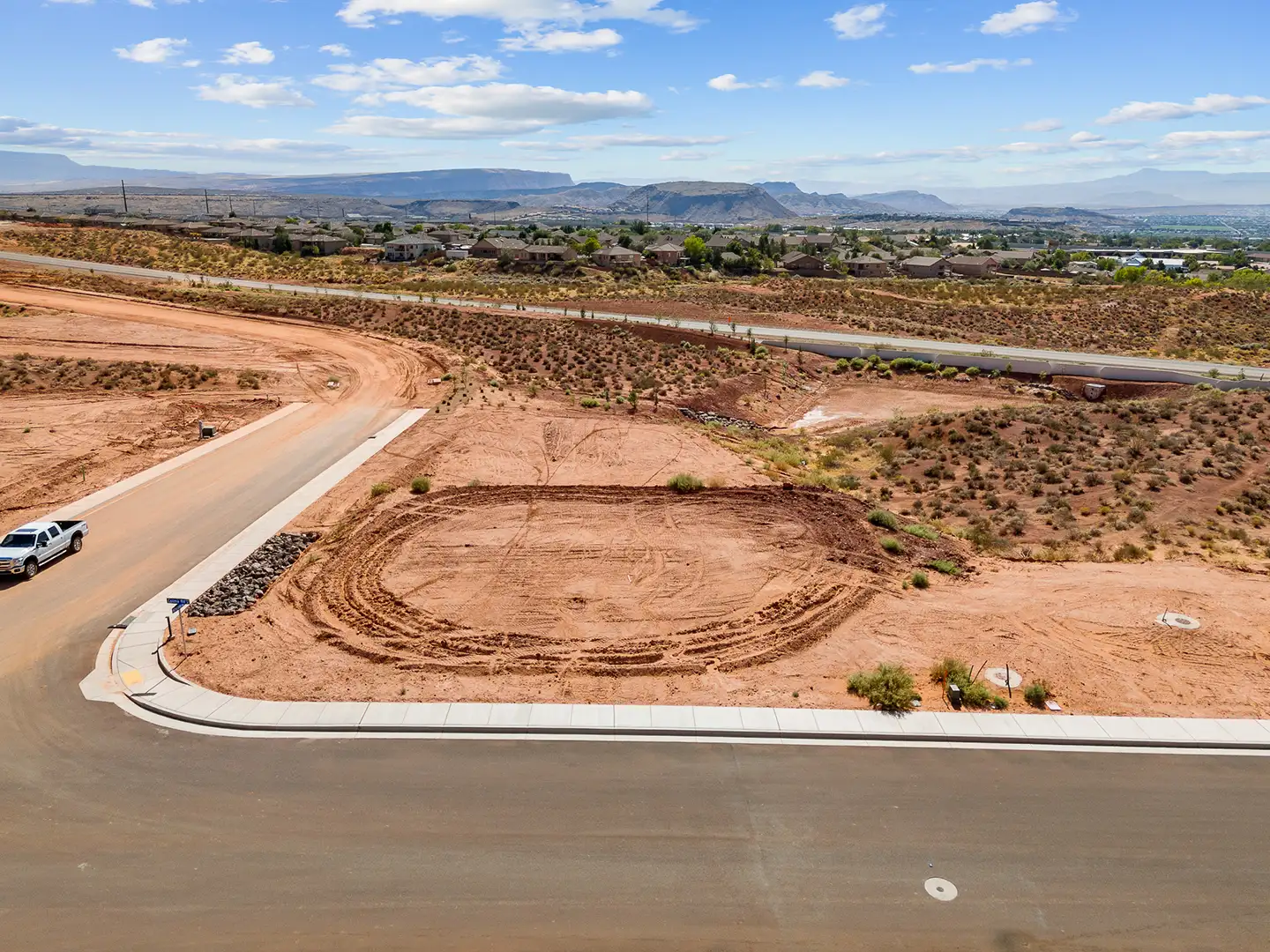 Aerial view of a cul-de-sac home lot with panoramic views of distant mesas, neighborhoods, and desert landscape
