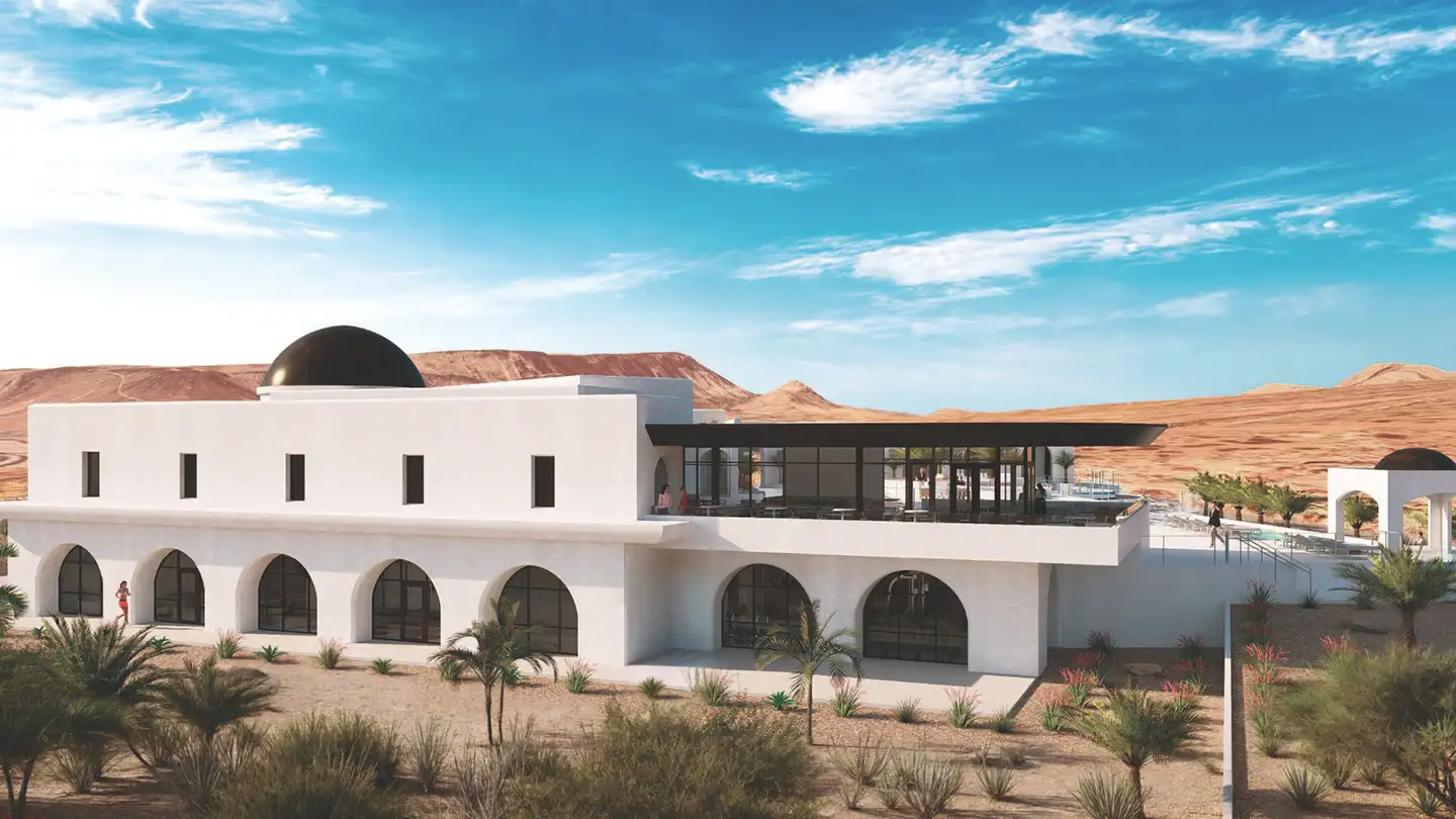 Aerial view of Solente community development with winding paved roads through red rock desert terrain and distant mountains