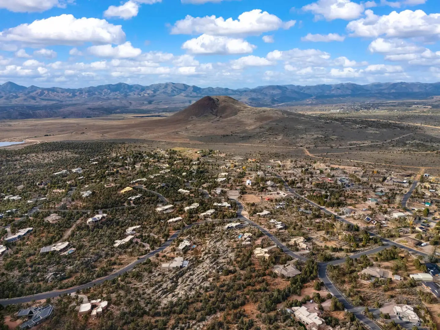 Aerial view of a residential area with a prominent cone-shaped hill rising from the surrounding high-desert valley.