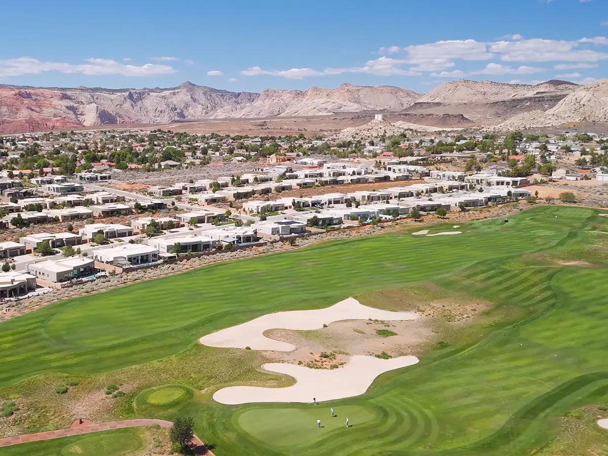 Aerial of The Ledges golf course community with manicured fairways, modern desert homes, and red mountain views.
