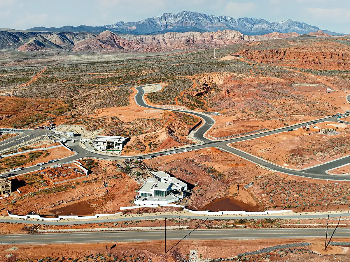 Aerial view of Solente community's winding desert roads carved through red rock terrain near St. George, Utah.