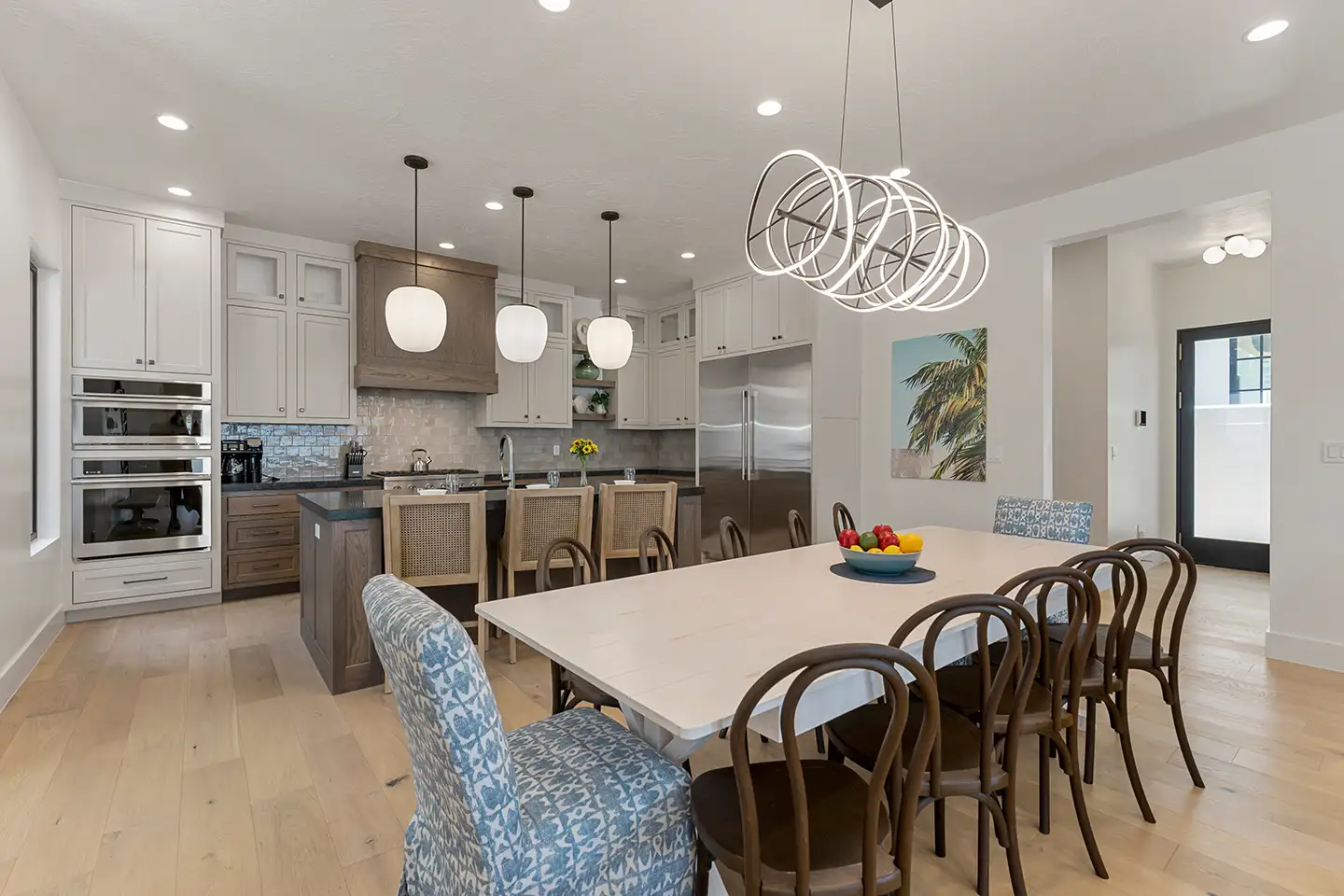Open-concept kitchen with a large dining table and seating for many guests in a luxury home.