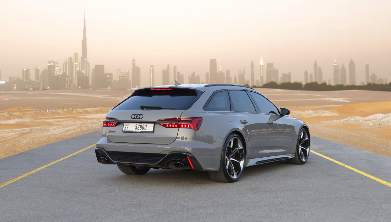 Gray Audi RS6 wagon parked on road with Dubai skyline in background