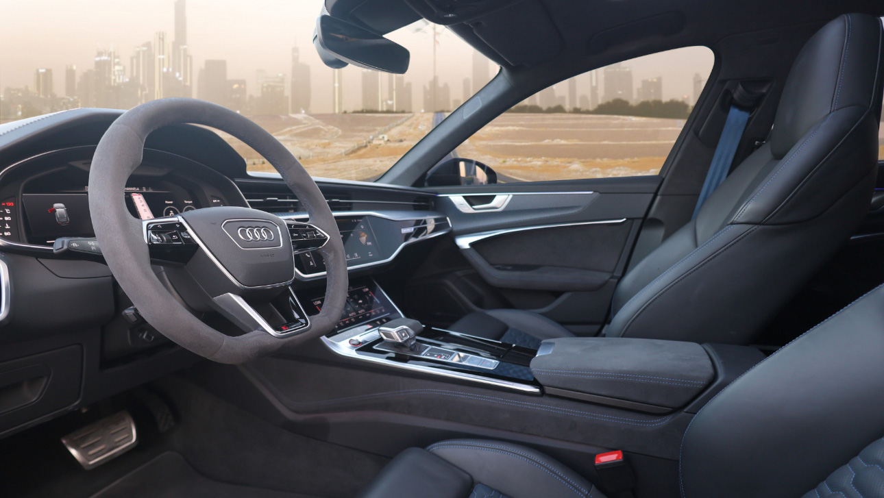 Interior of an Audi sedan with cityscape visible through windshield