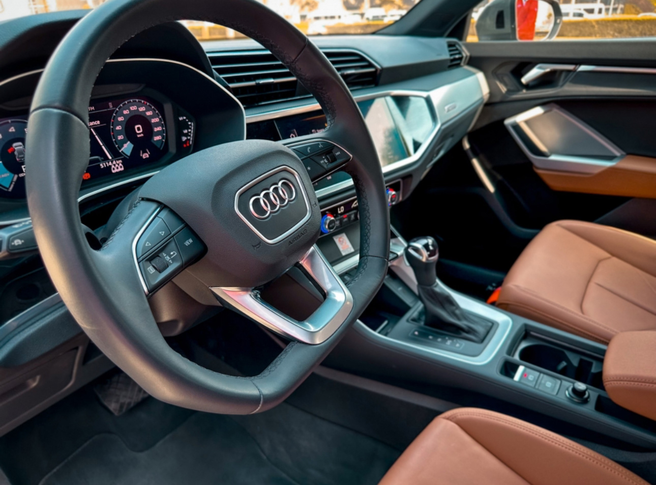 Interior of an Audi car with steering wheel, dashboard, and leather seats