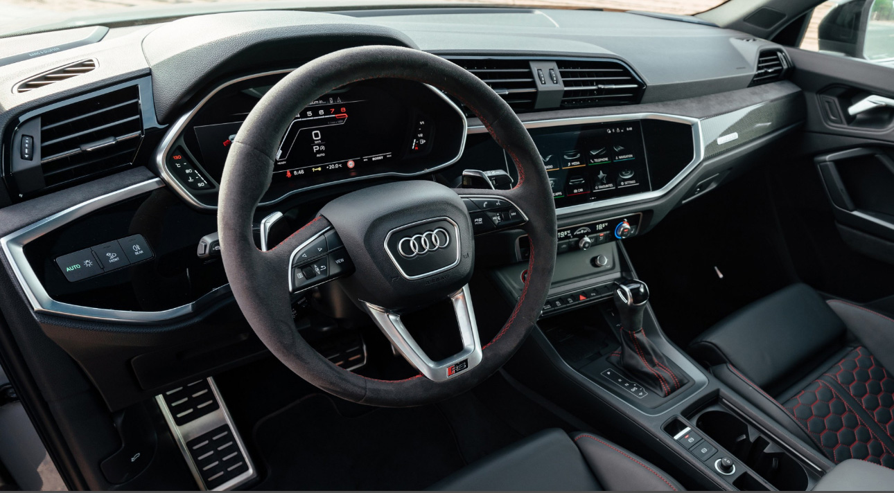 Interior of an Audi vehicle with digital dashboard and sporty steering wheel