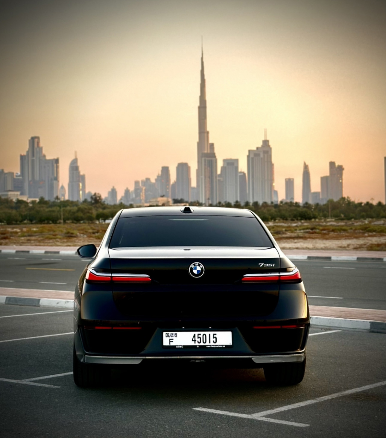 Black BMW parked with Dubai skyline and Burj Khalifa in background