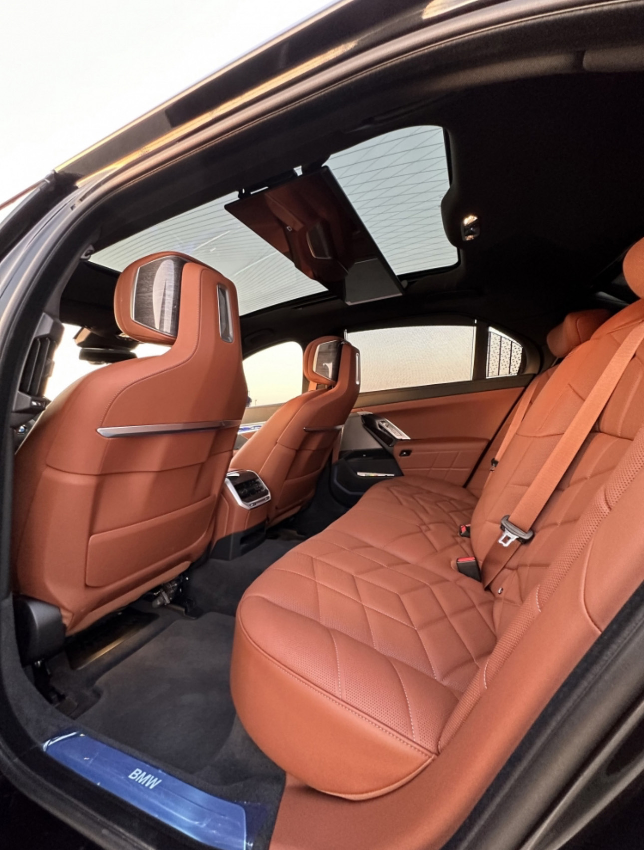 Luxury BMW interior with tan leather seats and panoramic sunroof