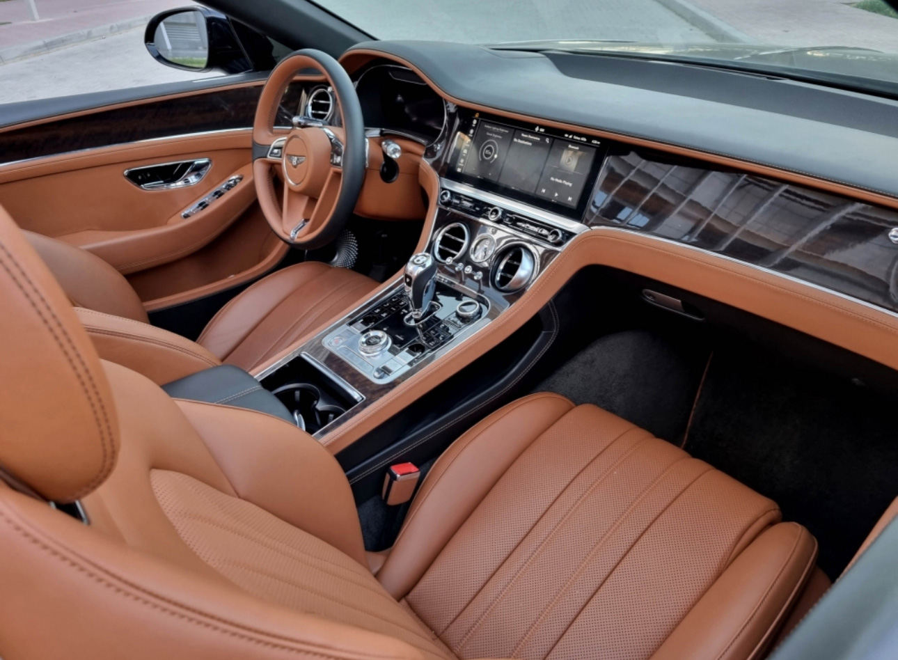 Luxurious Bentley interior with tan leather seats and modern dashboard