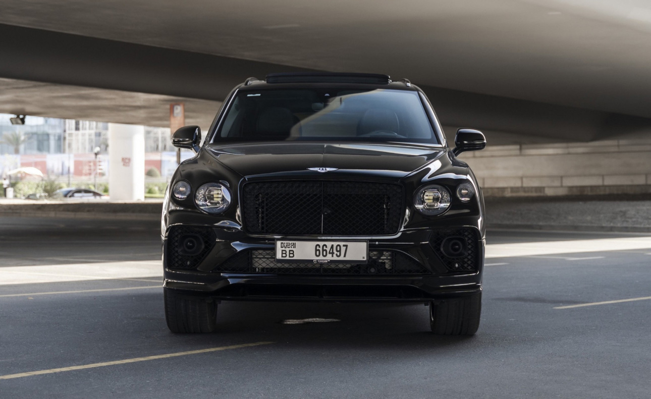 Black Bentley SUV parked under a concrete structure in Dubai