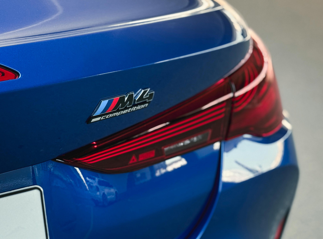 Blue BMW M2 Competition rear taillight and badge closeup
