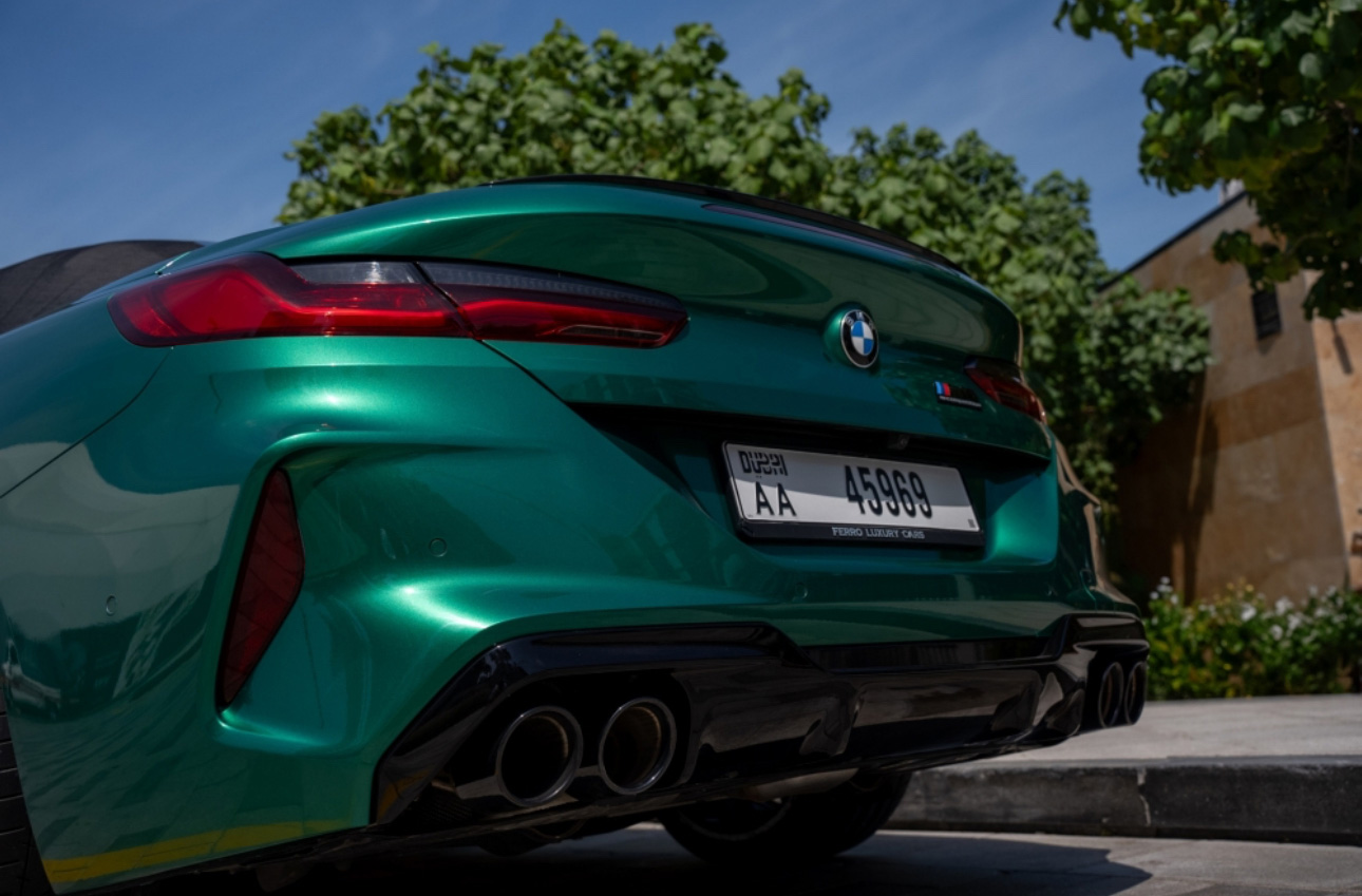 Emerald green BMW sports car with sleek rear view and quad exhaust