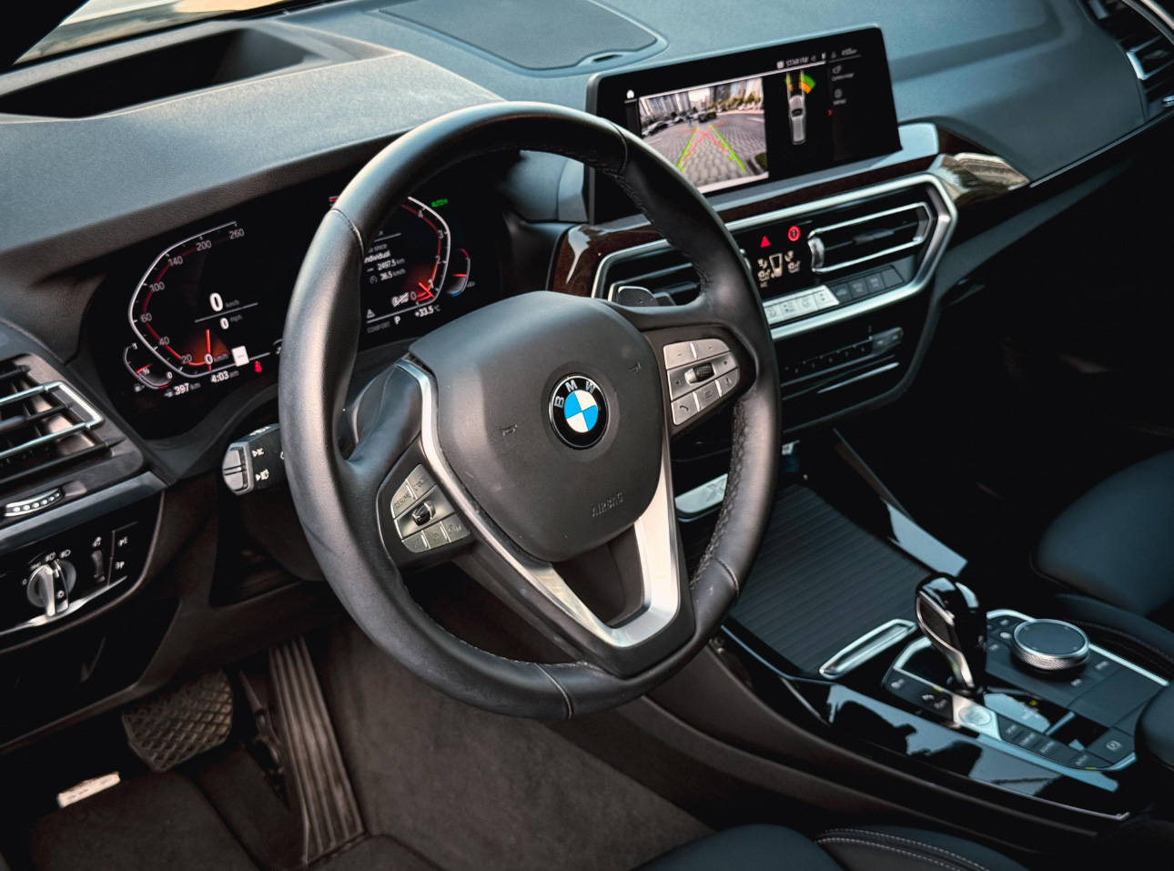 BMW car interior with steering wheel, dashboard, and infotainment display
