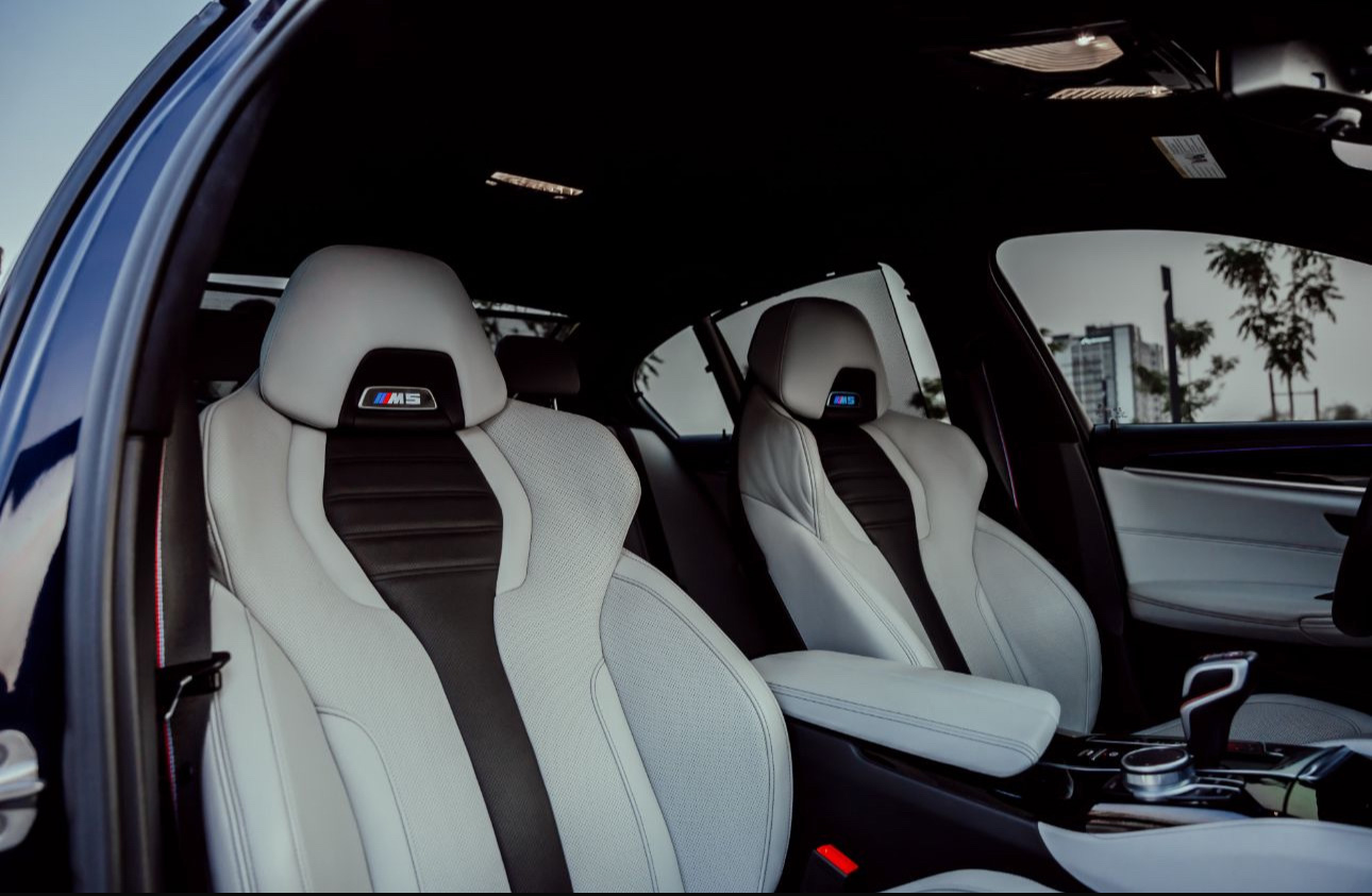 BMW M5 white leather interior with sporty seats and city view