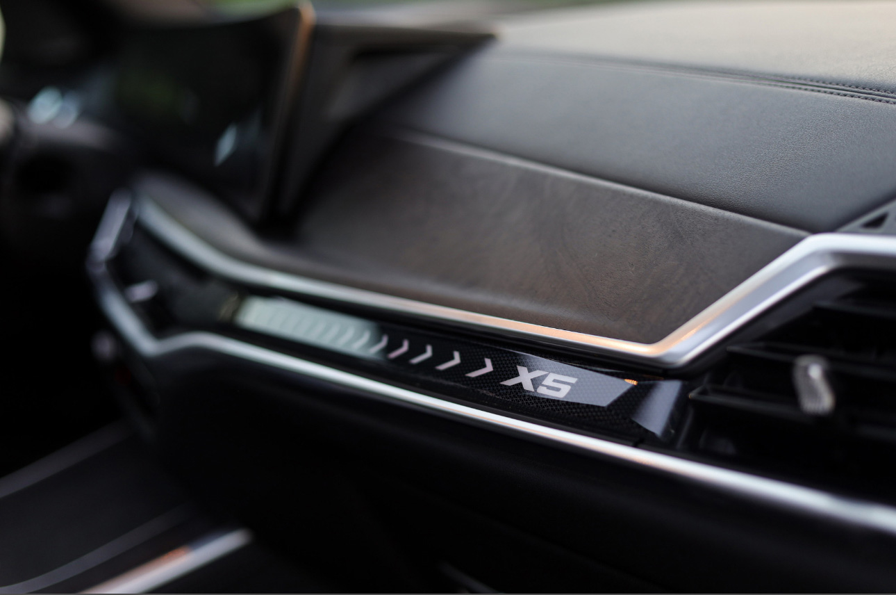 BMW X5 dashboard interior trim with model badge and metallic accents