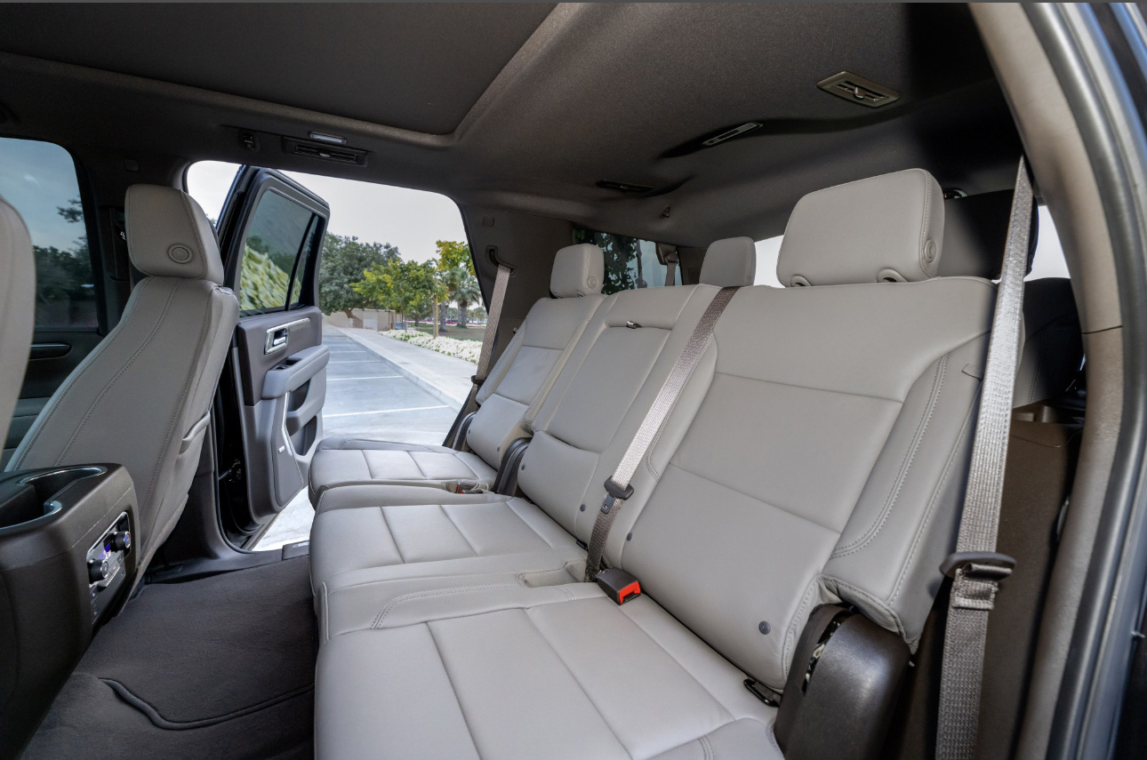 Spacious white leather interior of a modern SUV with open door