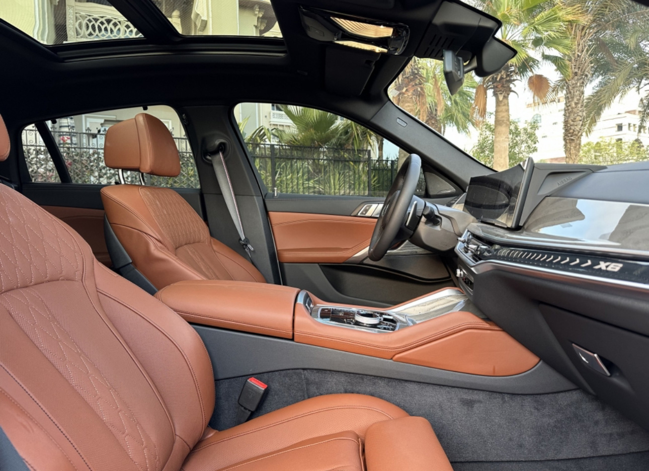 Luxury car interior with tan leather seats and modern dashboard
