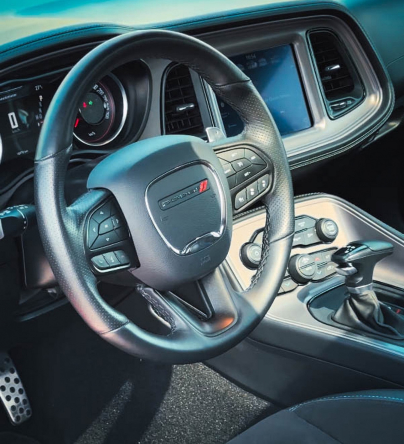Interior of a modern Dodge vehicle with steering wheel and dashboard