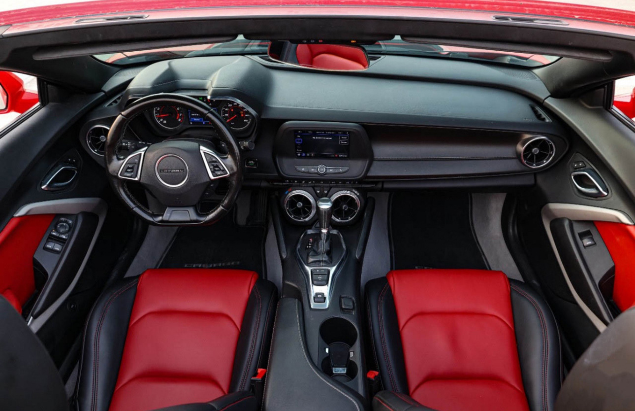 Red and black interior of a modern sports car with dashboard and seats