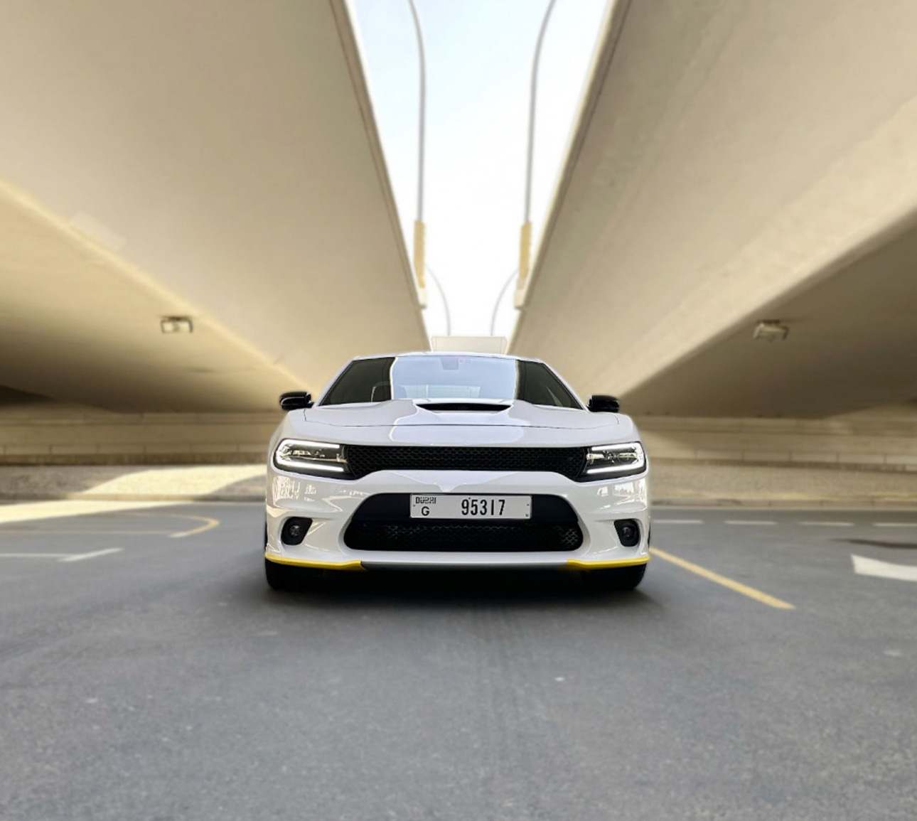 White sports car parked in minimalist concrete parking garage