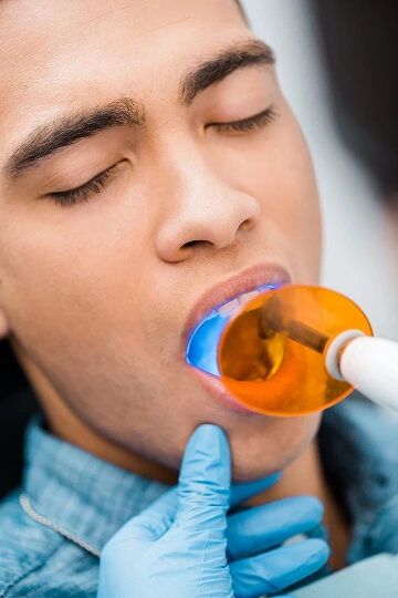 Teeth whitening procedure with LED light at dental clinic