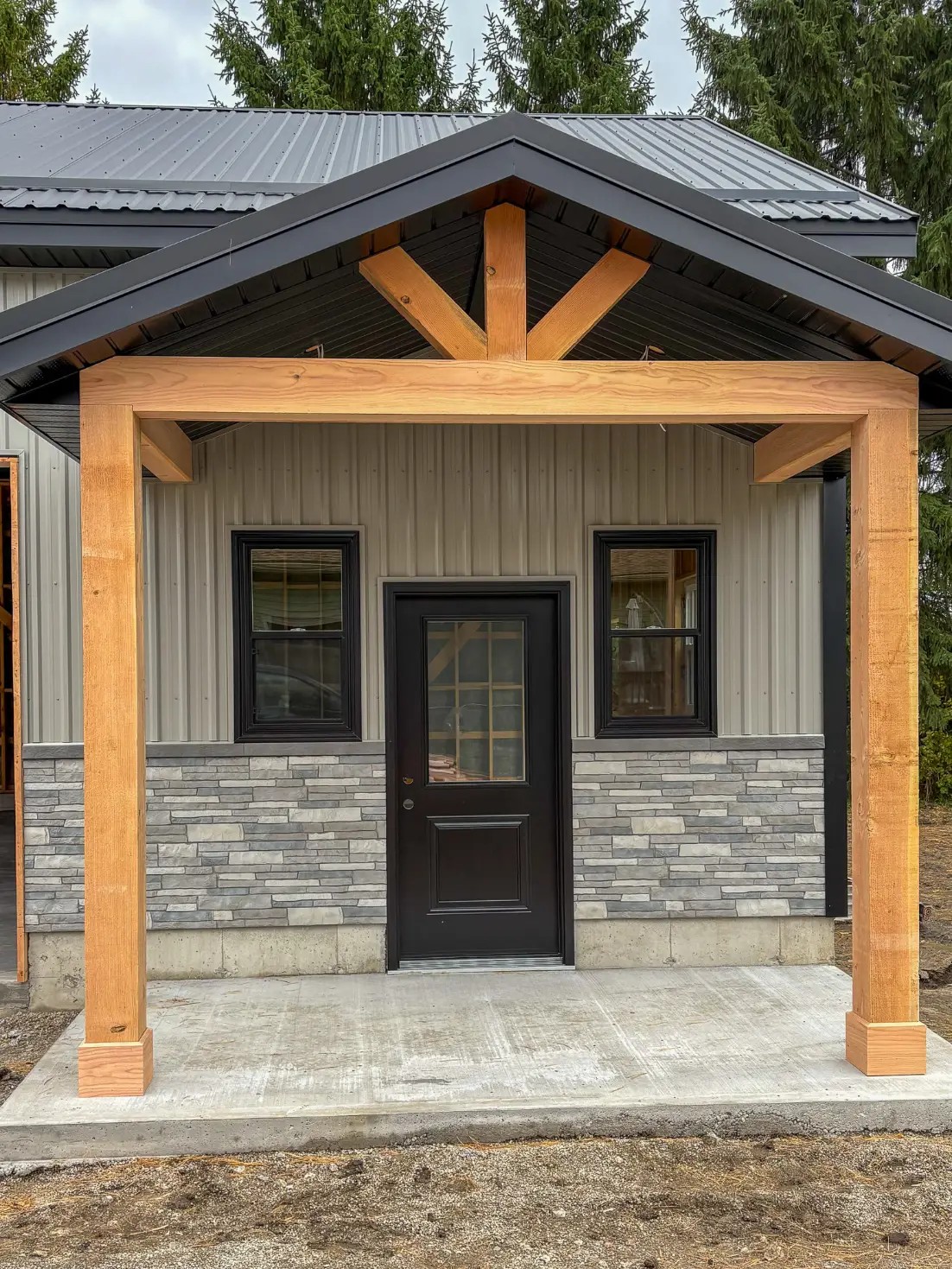 Photo of Grey Cladding, Black Trim, Wooden Entrance to a garage by Brouwer Metal Systems