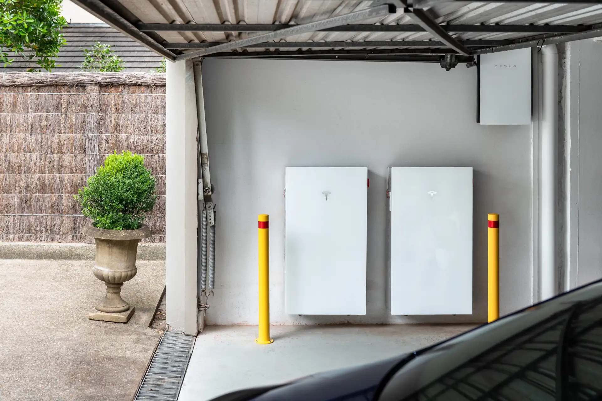Two Tesla Powerwall 3 batteries and Backup Gateway 2 wall-mounted in a residential carport with all cabling concealed within the wall cavity — Solarbank installation, St Ives