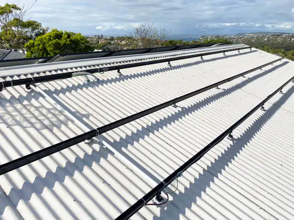Clenergy mounting rails and solar panels installed on a corrugated iron roof with neatly routed cabling — Solarbank installation, Sydney
