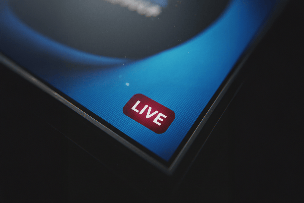 Nahaufnahme eines Bildschirms mit einem roten "LIVE"-Button als Symbol für rechtliche Fragen im Medienrecht.