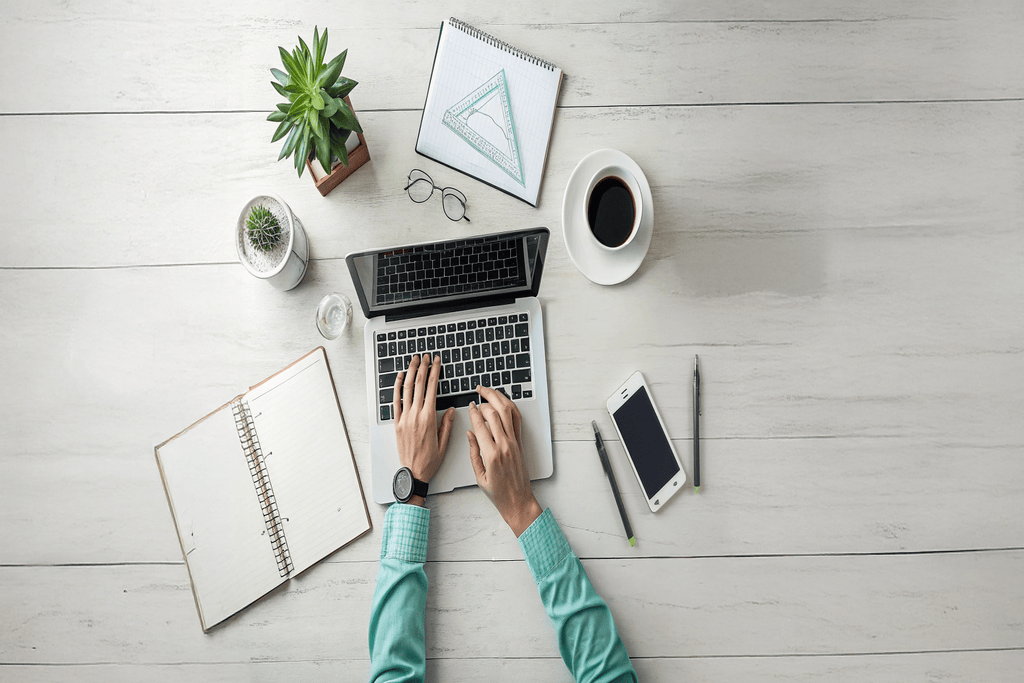Person arbeitet am Laptop an einem aufgeräumten Schreibtisch als Symbol für die moderne Online-Rechtsberatung.