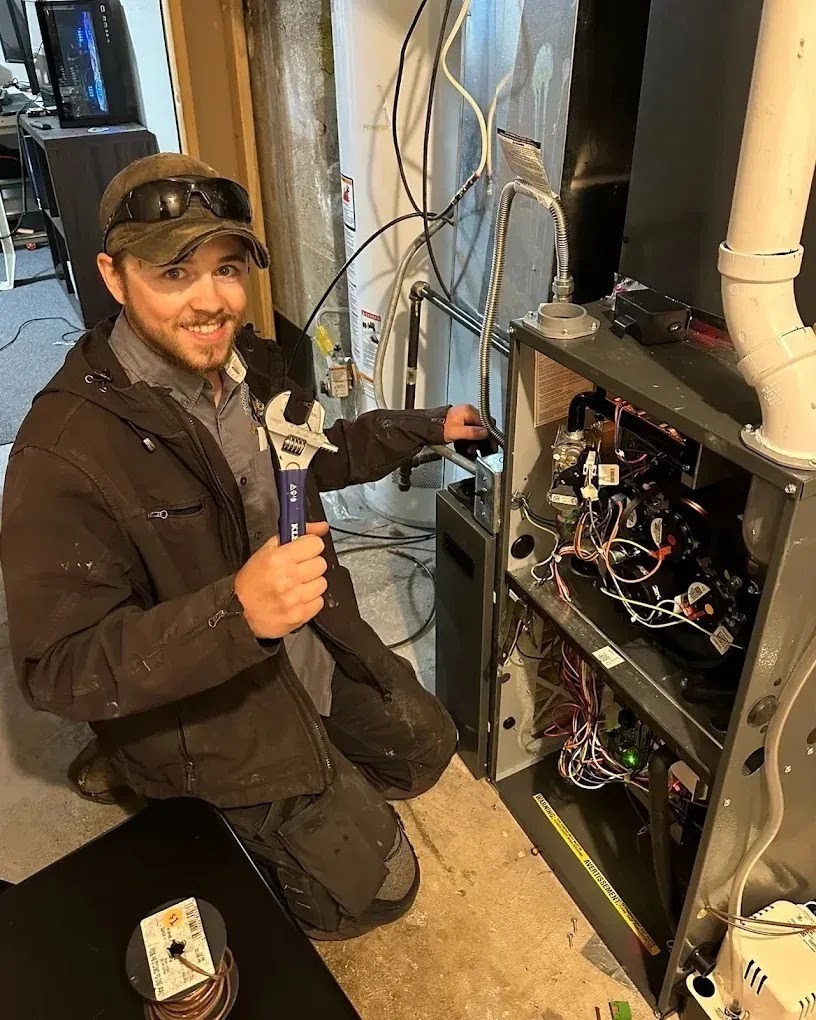HVAC technician inspecting an air conditioning unit indoors for maintenance